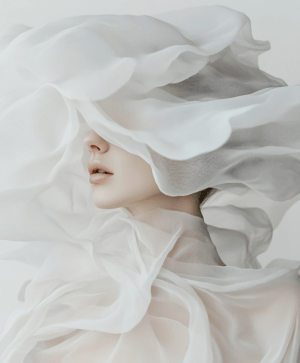 A serene figure draped in translucent white fabric, softly illuminated, creating a dreamlike atmosphere of mystery and elegance.