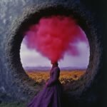 A figure in a purple gown with red smoke rising from her head, framed by a circular opening that reveals a vivid, warm landscape, exploring themes of creativity and introspection.