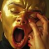 A powerful gold mask with a silent scream, contrasting with a gentle hand, symbolizing the struggle between vulnerability and connection, encapsulating the complexity of the human spirit.