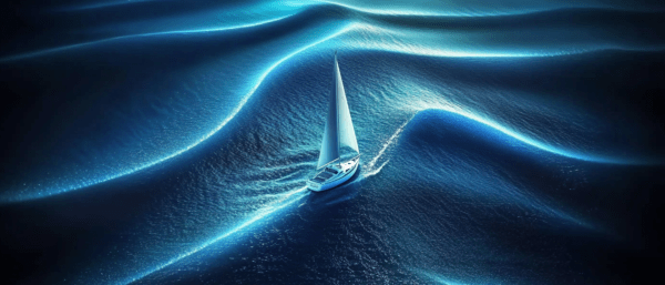 A sailboat with white sails gliding over luminous waves in a deep blue ocean, with shimmering light reflecting off the water, creating a peaceful and serene maritime scene.