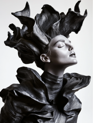 A sculptural figure with sweeping, fluid lines resembling waves or petals, evoking a sense of elegance and motion.
