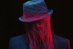 A figure with a shrouded face, vibrant blue and red strands flowing from a stylish hat, set against a dark background, symbolizing the complexity of identity and perception.